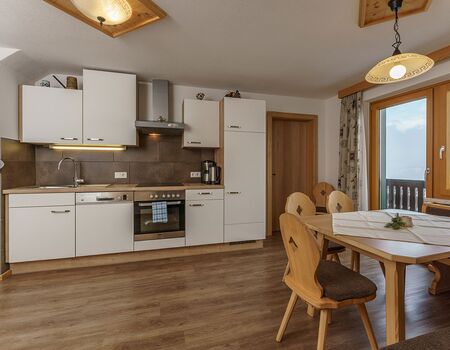 apartment Dachstein - charming kitchen and balcony with a view to dachstein glacier